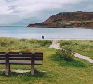 The lovely beach at Calgary Bay, Mull. Two people on the beach admiring the views.