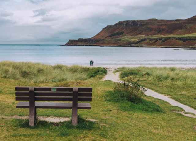 The lovely beach at Calgary Bay, Mull. Two people on the beach admiring the views.