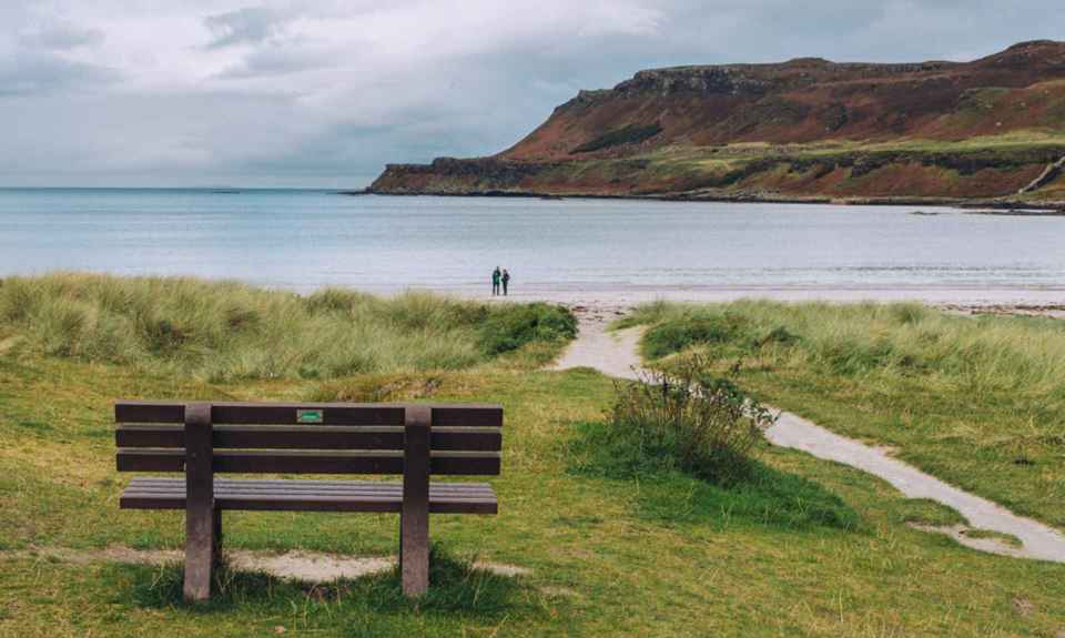 The lovely beach at Calgary Bay, Mull. Two people on the beach admiring the views.