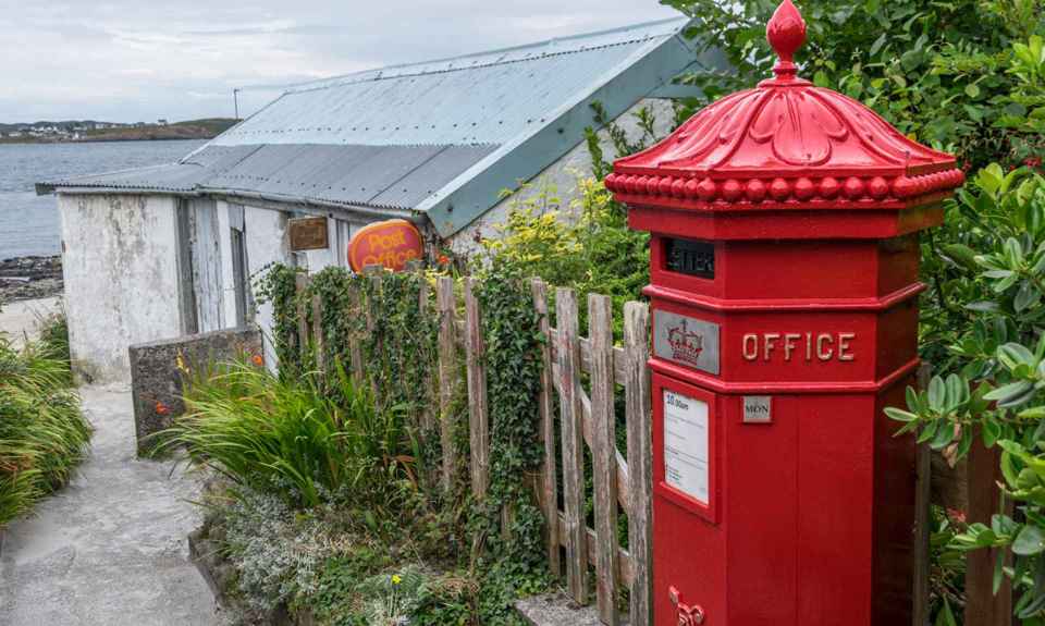 The famous red Royal Mail post boz and small lane to the post office building.