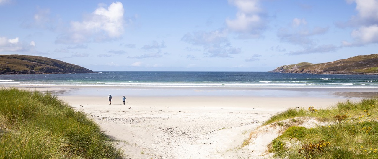 Two people walking on Vatersay beach