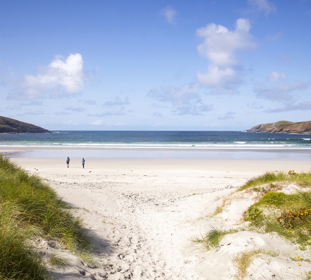 Two people walking on Vatersay beach