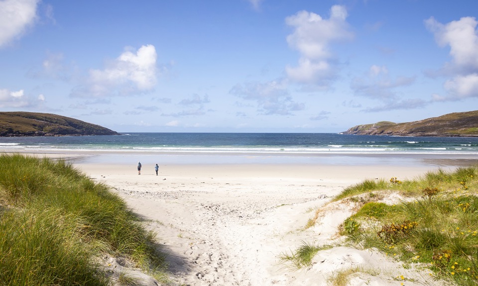 Two people walking on Vatersay beach