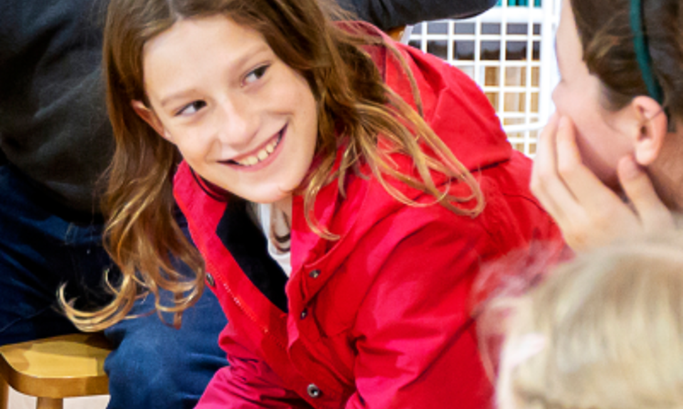 Young girl on a ferry smiling at a friends
