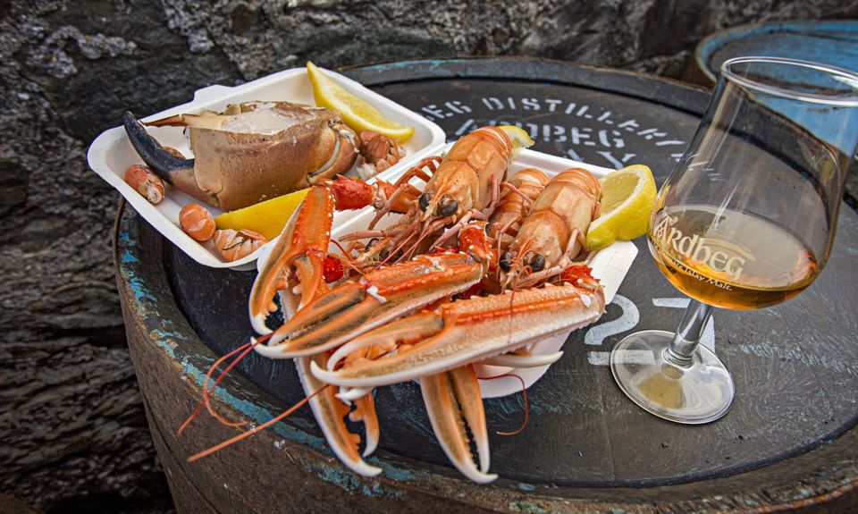 A plate of fresh seafood sitting next to a glass of whisky