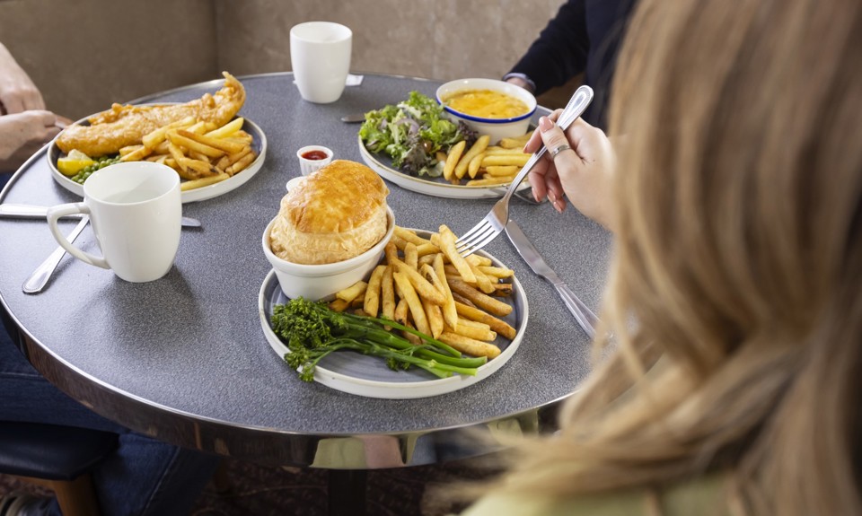 three people sitting in Mariners Cafe eating food