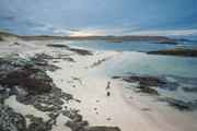 An aerial view of a person walking on Cliad Bay on Coll at sunset.