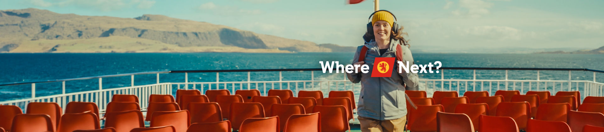 Brunette female standing on outer deck of ferry with red seats surrounding her, with the words 'Where Next' and a calmac logo across the image. 