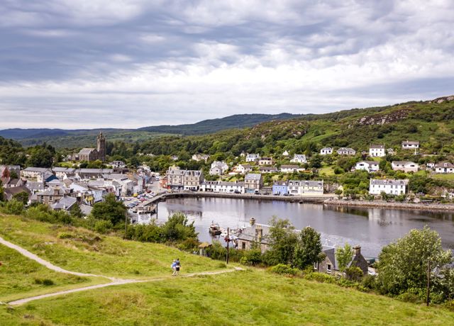 A view from a hilltop of the village of Tarbert in Kintyre. The village and houses spread around the bay.