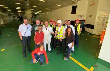 Image of the crew of the CalMac MV Isle of Lewis on an empty car deck, with customers they supported.