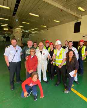 Image of the crew of the CalMac MV Isle of Lewis on an empty car deck, with customers they supported.