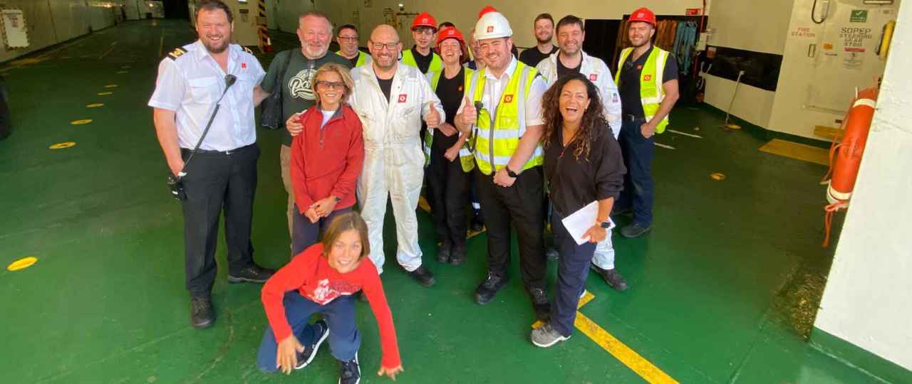 Image of the crew of the CalMac MV Isle of Lewis on an empty car deck, with customers they supported.