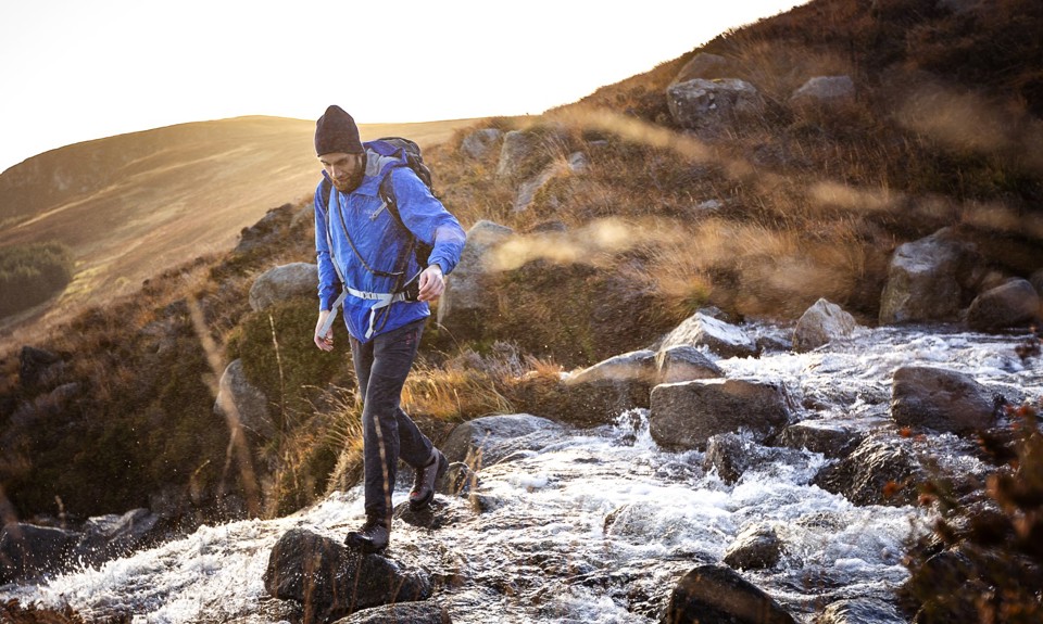 man walking down stones on Glen Rosa with the water from the stream flowing down past him