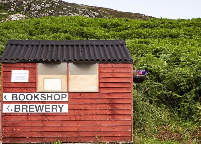 A wooden hut with signage point to the Bookshop and Brewery