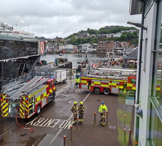 Fire and rescue vehicles positioned beside a CalMac ferry at Oban harbour during an emergency response exercise or incident.