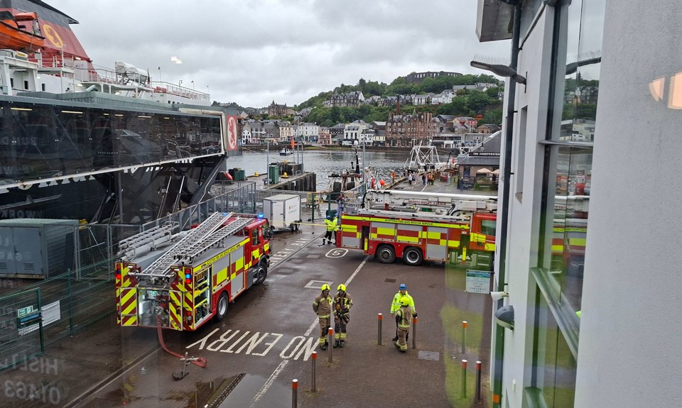 Fire and rescue vehicles positioned beside a CalMac ferry at Oban harbour during an emergency response exercise or incident.