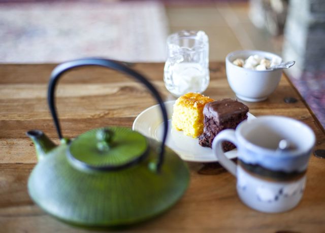 A table with tea pot and cakes set out for two, Isle of Muck, cafe.