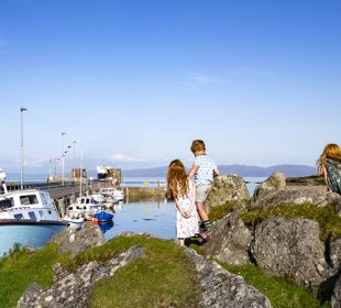 Children exploring the harbourside of Colonsay on a summer day