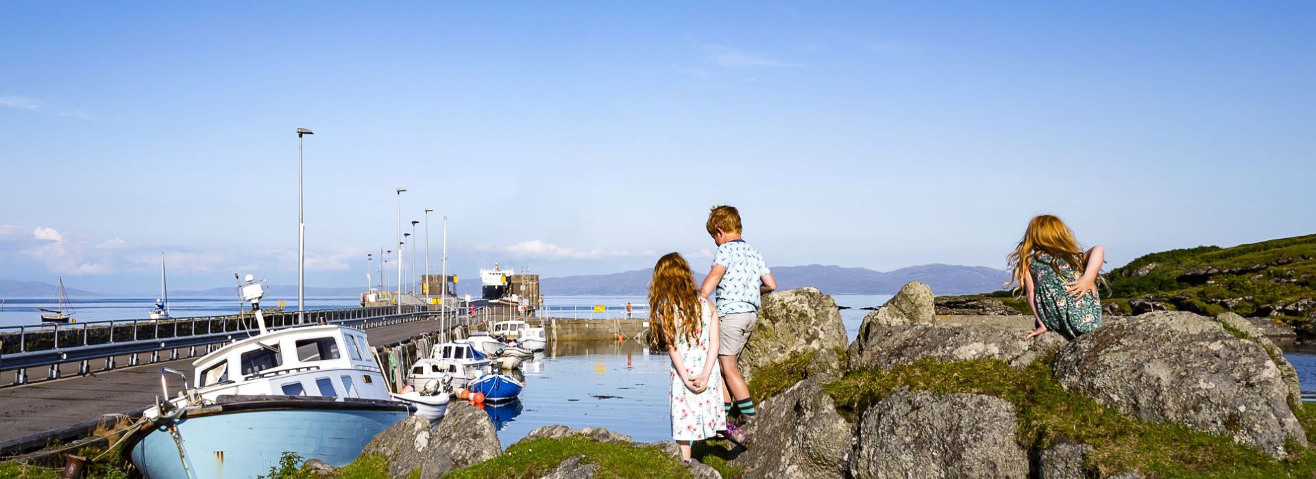 Children exploring the harbourside of Colonsay on a summer day