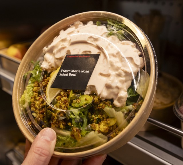 a prawn marie rose salad bowl in a paper bowl being placed on a shelf