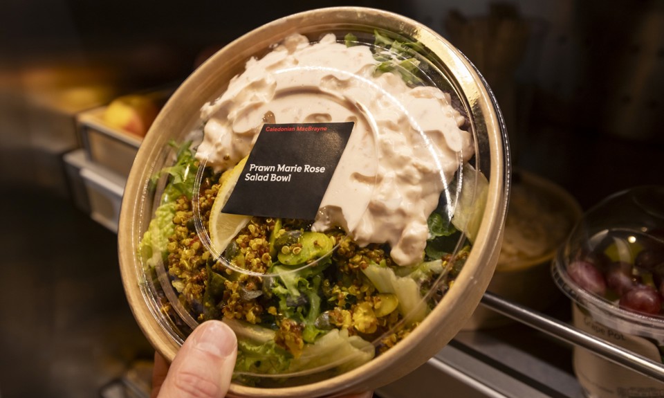 a prawn marie rose salad bowl in a paper bowl being placed on a shelf