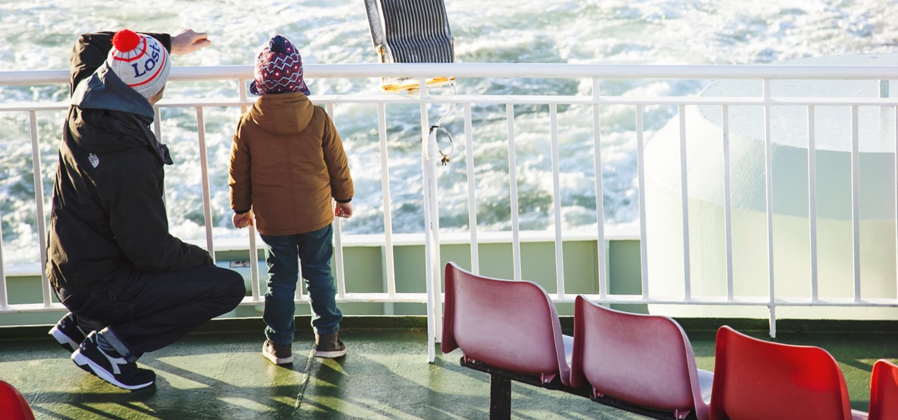 little boy and his dad on the boat deck looking out to sea