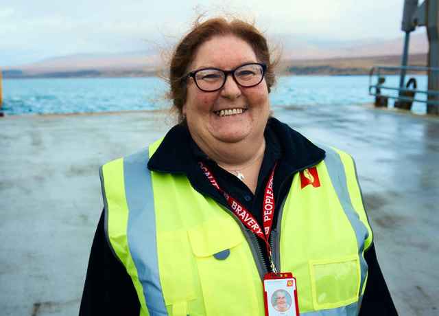 A picture of Terry, a CalMac Port Supervisor out on the Port in her high visibility workwear.