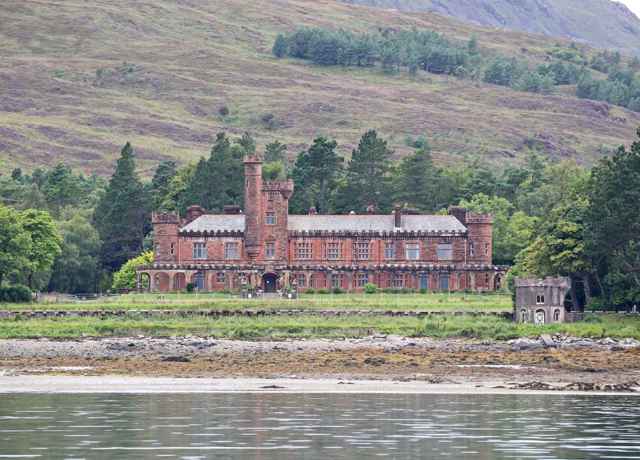 A view of the outside of Kinloch Castle, with hills behind. Rum.