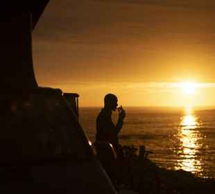 Sunset on Barra, with a person enjoying a drink outside