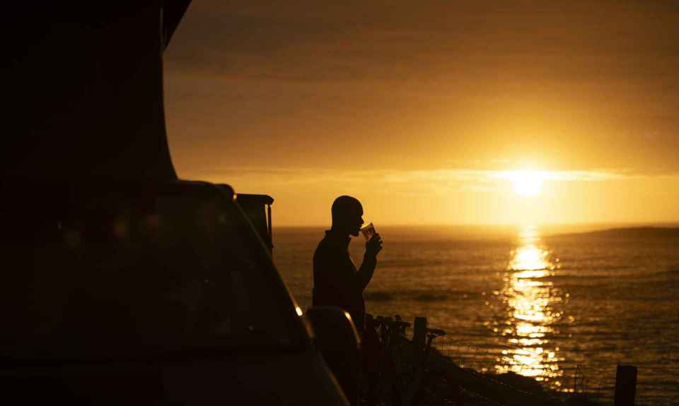 Sunset on Barra, with a person enjoying a drink outside