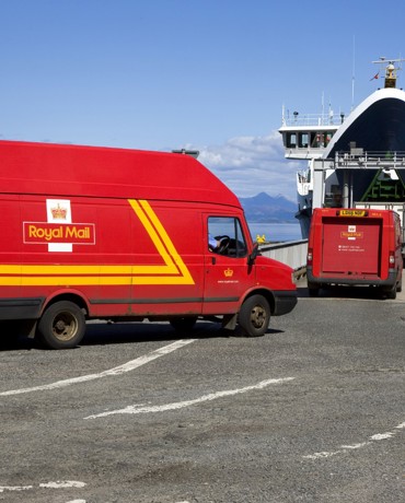 Royal Mail red van driving onto a CalMac ferry.