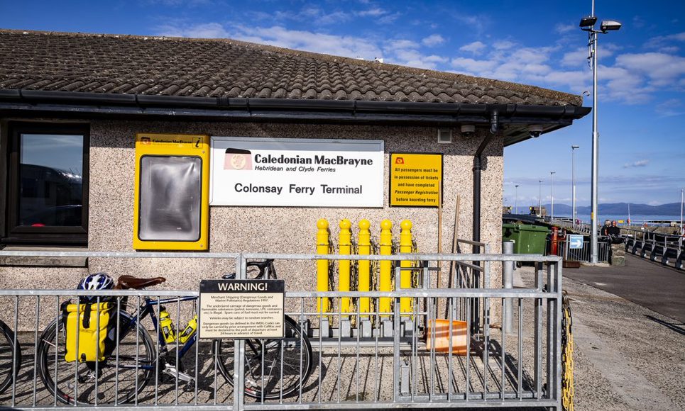 Caledonian MacBrayne Colonsay Ferry Terminal with a bicycle and luggage parked outside the building.
