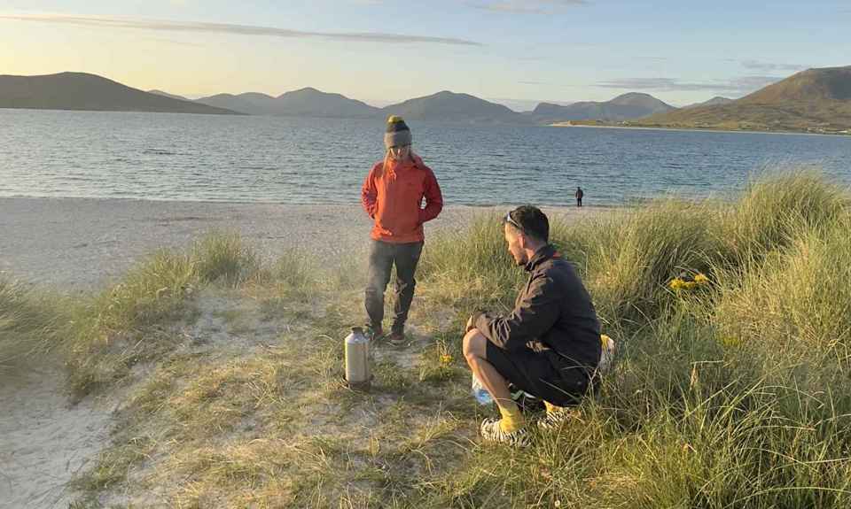 Two people enjoying an hot drink on a beach in Harris