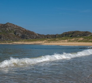 the waves coming in on Kiloran Bay, Isle of Colonsay with the mountains in the background