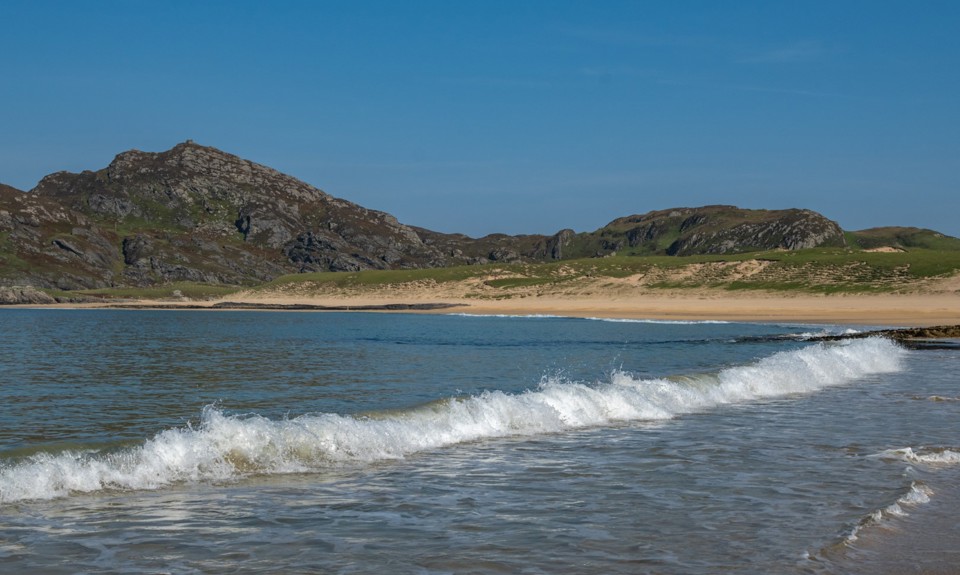 the waves coming in on Kiloran Bay, Isle of Colonsay with the mountains in the background