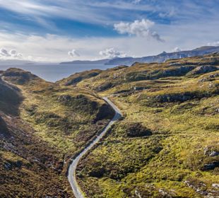 An aerial view of Calums road winding its way up the hilly landscap3 of Raasay.