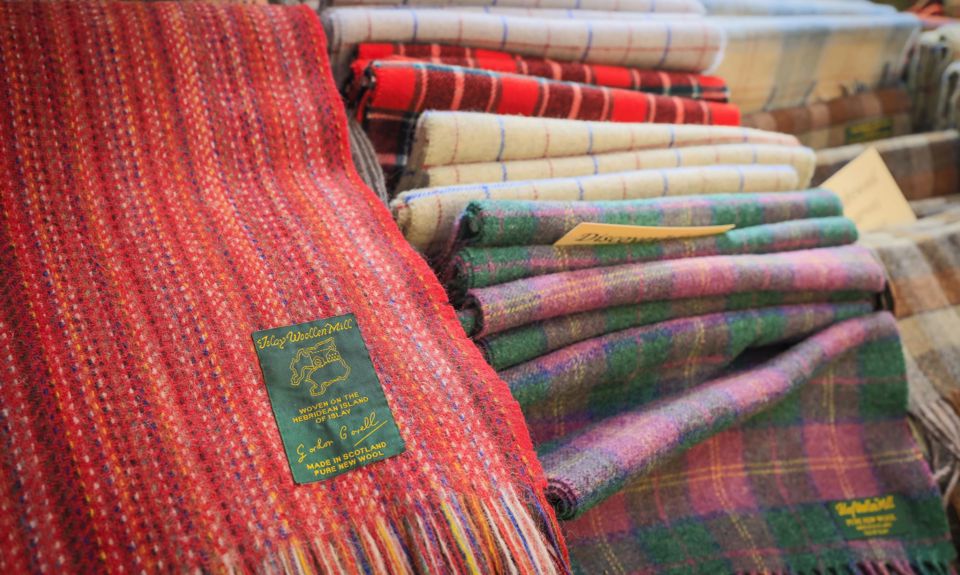 A clourful selection of Islay woolen mill scarves laid out on a display table