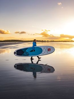 A Stand up paddle boarder on the beach at sunset, Tiree