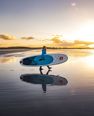A Stand up paddle boarder on the beach at sunset, Tiree