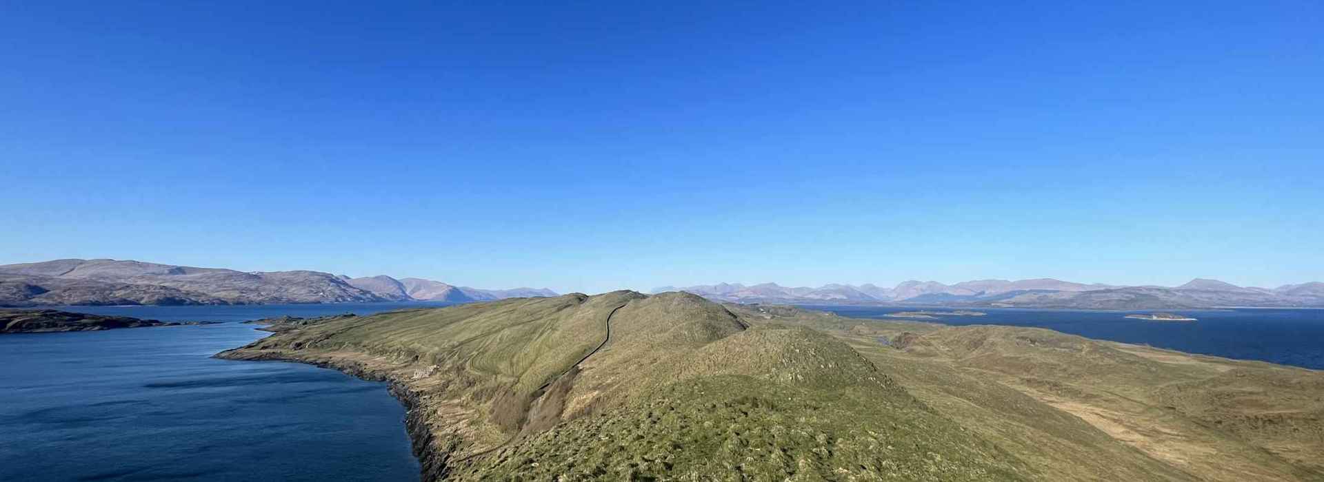 An aerial view of the isle of Lismore, green rolling hills and coastline.