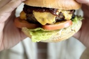 Close up of a burger being held by two hands