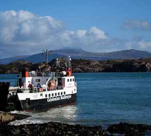 A CalMac ferry, docking at a slipway