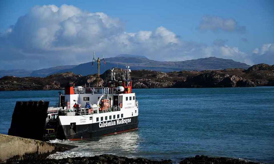 A CalMac ferry, docking at a slipway