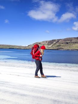 A walker on a beautiful sandy beach under a blue sky