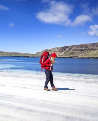 A walker on a beautiful sandy beach under a blue sky
