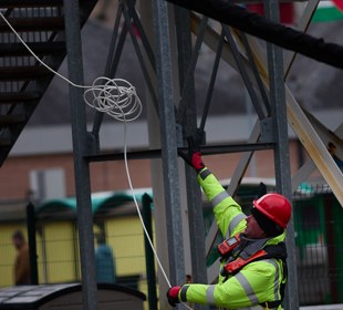 Port operative on the quayside handling a heaving line beside ferry infrastructure at Oban harbour.