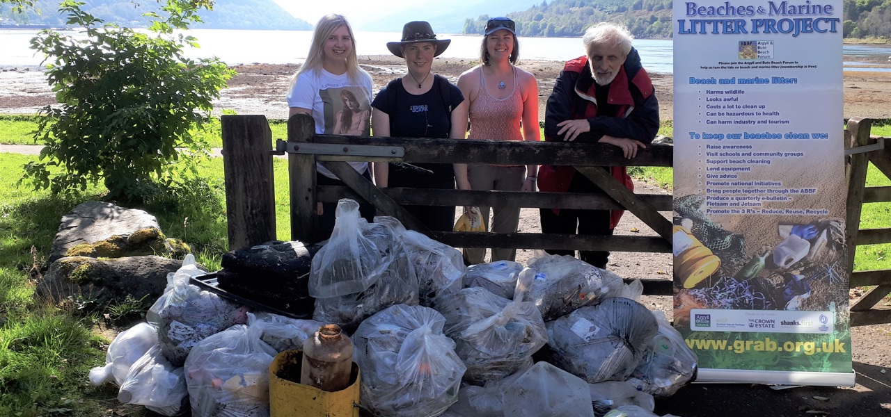 The GRAB Trust volunteers stand behind rubbish collected during beach clean at Arrochar