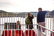 Father and his daughters standing on deck looking out to sea