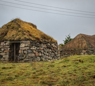  Turf roofed buildings at Sorisdale on The Isle of Coll located on a grass embankment
