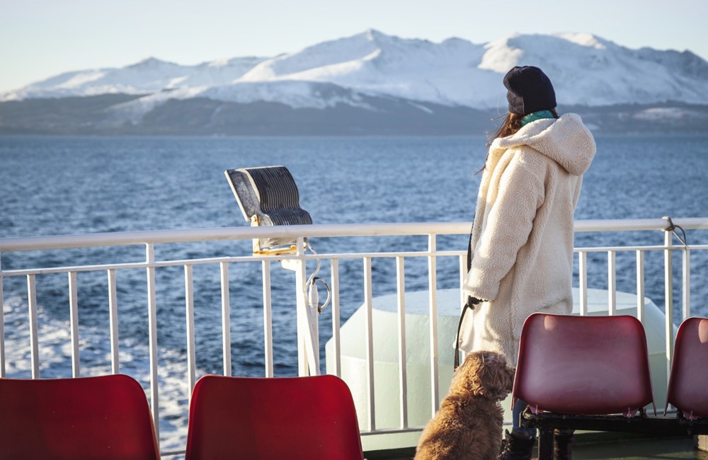 lady and her dog looking out from the deck of the boat